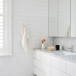 Mid-sized contemporary master bathroom in Melbourne with white cabinets, white tile, subway tile, white walls, marble floors, an undermount sink, marble benchtops, grey floor, white benchtops and flat-panel cabinets.