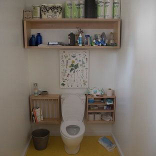 Inspiration för ett nordiskt badrum, med öppna hyllor, skåp i ljust trä, en toalettstol med separat cisternkåpa, vita väggar, gult golv, en dusch i en alkov, ett väggmonterat handfat och med dusch som är öppen