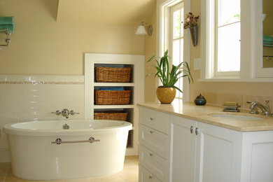 Freestanding bathtub - freestanding bathtub idea in San Francisco with white cabinets and yellow walls