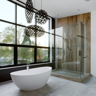 Immagine di una grande stanza da bagno padronale contemporanea con vasca freestanding, piastrelle marroni, pavimento in cemento e doccia doppia