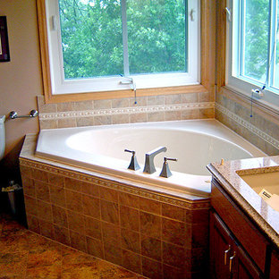 Example of a mid-sized classic master ceramic tile and beige tile ceramic tile and beige floor bathroom design in Minneapolis with raised-panel cabinets, medium tone wood cabinets, a two-piece toilet, beige walls, an undermount sink, granite countertops and a hinged shower door