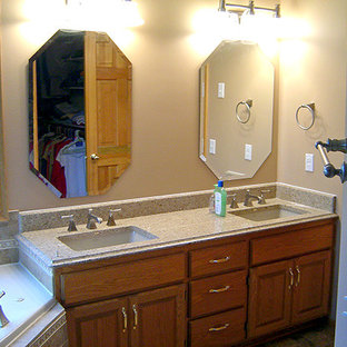 Inspiration for a mid-sized timeless master ceramic tile and beige tile ceramic tile and beige floor bathroom remodel in Minneapolis with raised-panel cabinets, medium tone wood cabinets, a two-piece toilet, beige walls, an undermount sink, granite countertops and a hinged shower door
