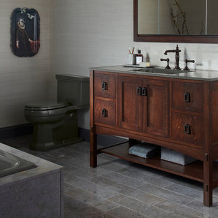 Mid-sized elegant master gray tile marble floor drop-in bathtub photo in Milwaukee with an integrated sink, shaker cabinets, dark wood cabinets, solid surface countertops, a one-piece toilet and gray walls