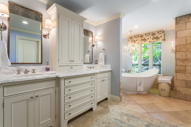 На фото: большая главная ванная комната в классическом стиле с накладной раковиной, белыми фасадами, мраморной столешницей, отдельно стоящей ванной, синими стенами и полом из керамической плитки с