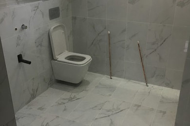 Photo of a medium sized modern ensuite bathroom in Other with a walk-in shower, a wall mounted toilet, black and white tiles, porcelain tiles, white walls, porcelain flooring and a wall-mounted sink.