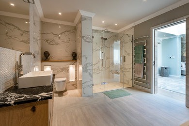 Inspiration for a large modern ensuite bathroom in Other with an alcove shower, a wall mounted toilet, white tiles, marble tiles, white walls, porcelain flooring, a built-in sink, marble worktops, grey floors, a hinged door and black worktops.