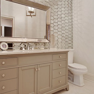 Design ideas for a mid-sized bathroom in New Orleans with a two-piece toilet, mirror tile, white walls, an undermount sink and marble benchtops.