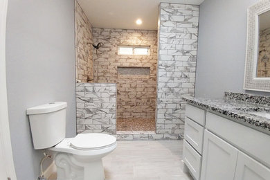 Example of a mid-sized minimalist master gray tile and marble tile porcelain tile and gray floor bathroom design in Albuquerque with raised-panel cabinets, white cabinets, gray walls, an undermount sink, granite countertops and gray countertops