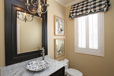 Example of a small trendy 3/4 bathroom design in Seattle with a vessel sink, raised-panel cabinets, dark wood cabinets, marble countertops, a one-piece toilet and beige walls
