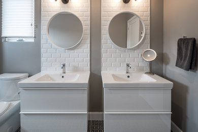 Example of a mid-sized trendy master white tile and ceramic tile mosaic tile floor doorless shower design in Ottawa with flat-panel cabinets, white cabinets, a two-piece toilet, gray walls, an integrated sink and solid surface countertops