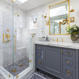 This is an example of a mid-sized traditional bathroom in San Francisco with grey cabinets, a corner shower, white tile, marble, white walls, mosaic tile floors, an undermount sink, grey floor, a hinged shower door, furniture-like cabinets and a shower seat.