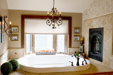 Klassisk inredning av ett mellanstort en-suite badrum, med luckor med profilerade fronter, skåp i mellenmörkt trä, bänkskiva i kalksten, beige kakel, beige väggar och travertin golv