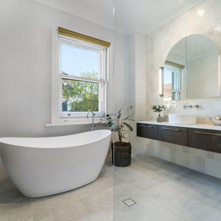 Design ideas for a large contemporary 3/4 bathroom in Sydney with furniture-like cabinets, brown cabinets, a freestanding tub, an open shower, a one-piece toilet, multi-coloured tile, ceramic tile, grey walls, ceramic floors, granite benchtops, multi-coloured floor, an open shower, white benchtops, a single vanity and a floating vanity.