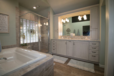 Example of a mid-sized transitional master porcelain tile and brown floor bathroom design in Other with recessed-panel cabinets, distressed cabinets, green walls, an undermount sink and quartz countertops