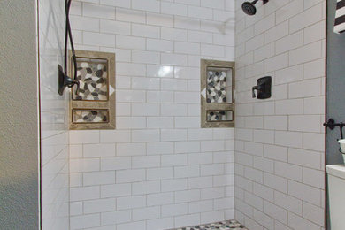 Transitional gray tile, white tile and pebble tile porcelain tile alcove shower photo in Denver with gray walls, raised-panel cabinets, white cabinets, an undermount sink and marble countertops