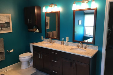 Bathroom - mid-sized transitional master travertine floor bathroom idea in Philadelphia with shaker cabinets, dark wood cabinets, a two-piece toilet, blue walls, an undermount sink and granite countertops