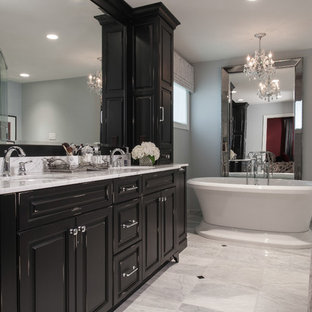 Mittelgroßes Klassisches Badezimmer En Suite mit Unterbauwaschbecken, profilierten Schrankfronten, schwarzen Schränken, Marmor-Waschbecken/Waschtisch, freistehender Badewanne, grauer Wandfarbe und Marmorboden in St. Louis
