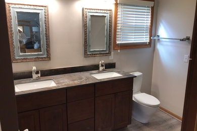 Inspiration for a mid-sized transitional 3/4 orange tile and porcelain tile vinyl floor and gray floor alcove shower remodel in Columbus with shaker cabinets, brown cabinets, a two-piece toilet, gray walls, an undermount sink, quartz countertops, a hinged shower door and gray countertops