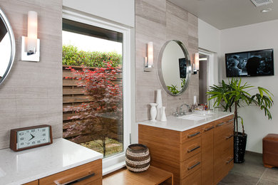 Modernes Badezimmer mit Unterbauwaschbecken, flächenbündigen Schrankfronten, hellbraunen Holzschränken und grauen Fliesen in Dallas