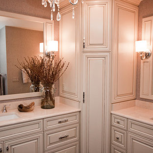 Mittelgroßes Shabby-Style Badezimmer En Suite mit profilierten Schrankfronten, beigen Schränken, freistehender Badewanne, Eckdusche, Wandtoilette mit Spülkasten, beigefarbenen Fliesen, Steinplatten, grauer Wandfarbe, Keramikboden, Unterbauwaschbecken, Mineralwerkstoff-Waschtisch, braunem Boden und Falttür-Duschabtrennung in Cleveland