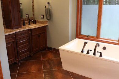 Inspiration for a large contemporary master brown tile and porcelain tile ceramic tile and brown floor bathroom remodel in Detroit with raised-panel cabinets, dark wood cabinets, a two-piece toilet, white walls, a drop-in sink, granite countertops and beige countertops