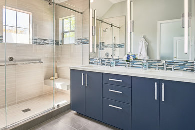Esempio di una stanza da bagno chic con ante lisce, ante blu, doccia alcova, piastrelle beige, pareti grigie, pavimento grigio, porta doccia scorrevole e top bianco