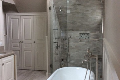 Example of a large transitional master stone tile bathroom design in New York with raised-panel cabinets, white cabinets, beige walls, an undermount sink, a hinged shower door, a two-piece toilet and quartz countertops
