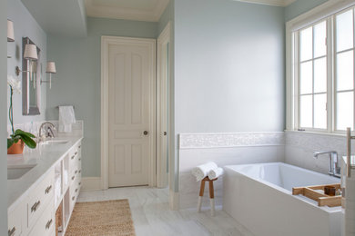 Inspiration pour une grande douche en alcôve principale traditionnelle avec un placard avec porte à panneau encastré, des portes de placard blanches, une baignoire indépendante, un mur bleu, un sol en marbre, un lavabo encastré et un plan de toilette en marbre.