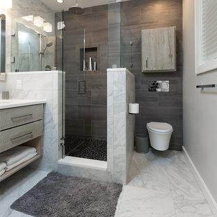 Imagen de cuarto de baño principal, minimalista, de tamaño medio, con puertas de armario con efecto envejecido, sanitario de pared, baldosas y/o azulejos multicolor, baldosas y/o azulejos de porcelana, paredes grises, suelo de baldosas tipo guijarro, lavabo bajoencimera y encimera de cuarzo compacto