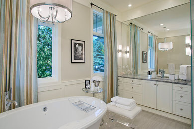 Klassisk inredning av ett stort en-suite badrum, med skåp i shakerstil, vita skåp, ett fristående badkar, grå väggar, vinylgolv, ett undermonterad handfat, granitbänkskiva och en hörndusch