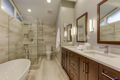 Master porcelain tile and beige floor freestanding bathtub photo in Minneapolis with dark wood cabinets, beige walls, an undermount sink, granite countertops and a hinged shower door