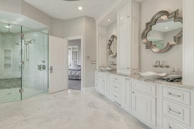 Large elegant master gray tile and stone slab marble floor and gray floor corner shower photo in DC Metro with raised-panel cabinets, white cabinets, gray walls, a vessel sink, granite countertops, a hinged shower door and gray countertops