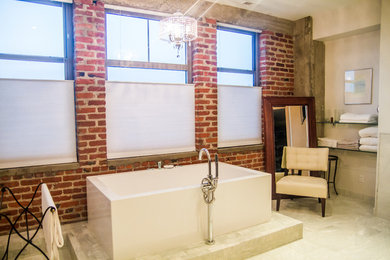 オマハにあるインダストリアルスタイルのおしゃれなマスターバスルーム (置き型浴槽、ベージュの壁、大理石の床、ベージュの床) の写真