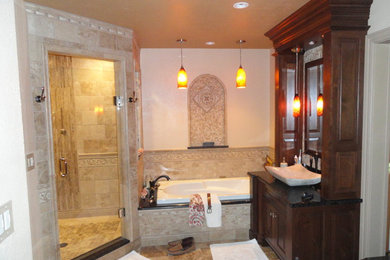 Example of a tuscan master beige tile travertine floor bathroom design in Other with a vessel sink, furniture-like cabinets, dark wood cabinets and laminate countertops