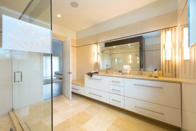 Inspiration for a large contemporary master beige tile and porcelain tile limestone floor, yellow floor and double-sink double shower remodel in DC Metro with flat-panel cabinets, beige cabinets, a one-piece toilet, an undermount sink, solid surface countertops, a hinged shower door, yellow countertops and a built-in vanity