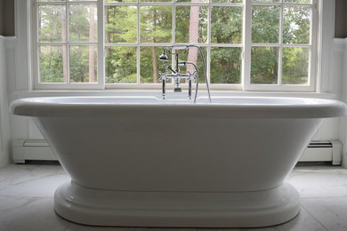 Large elegant master marble floor and gray floor freestanding bathtub photo in Boston with gray walls