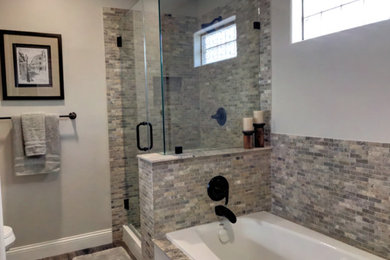 Mid-sized mountain style master travertine tile laminate floor and brown floor bathroom photo in Houston with white cabinets, gray walls, a drop-in sink, granite countertops, a hinged shower door and black countertops