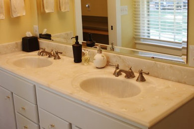 ワシントンD.C.にある中くらいなトラディショナルスタイルのおしゃれなマスターバスルーム (インセット扉のキャビネット、白いキャビネット、黄色い壁、一体型シンク、大理石の洗面台) の写真