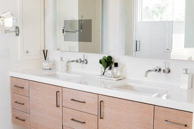 Trendy white floor bathroom photo in Other with white walls, white countertops, flat-panel cabinets, medium tone wood cabinets and an undermount sink