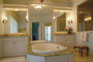 Inspiration for a large timeless master beige floor drop-in bathtub remodel in Tampa with raised-panel cabinets, white cabinets, gray walls, an undermount sink and granite countertops