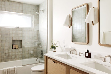 Example of a trendy 3/4 gray tile bathroom design in Other with flat-panel cabinets, light wood cabinets and an undermount sink