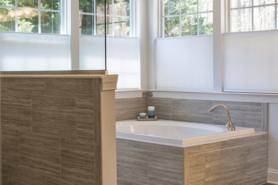 Example of a large transitional master gray tile and ceramic tile porcelain tile bathroom design in Baltimore with white cabinets, a one-piece toilet, an undermount sink, granite countertops, raised-panel cabinets and white walls