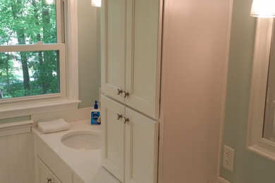 Inspiration for a mid-sized transitional master white tile doorless shower remodel in Philadelphia with an undermount sink, recessed-panel cabinets, white cabinets, quartz countertops, a one-piece toilet and blue walls