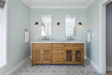 Mid-sized beach style master white tile and marble tile cement tile floor and multicolored floor corner shower photo in San Francisco with furniture-like cabinets, brown cabinets, marble countertops, blue walls and a hinged shower door