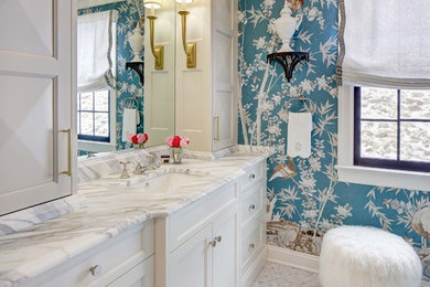 Modelo de cuarto de baño principal clásico con puertas de armario naranjas, paredes azules, suelo con mosaicos de baldosas, lavabo bajoencimera y suelo blanco