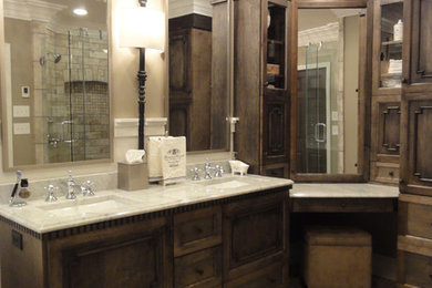 Bathroom - traditional beige tile and mosaic tile bathroom idea in Charlotte with an undermount sink, furniture-like cabinets, dark wood cabinets, marble countertops and a two-piece toilet