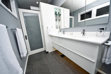 Ejemplo de cuarto de baño moderno con ducha a ras de suelo, paredes grises, suelo gris y encimeras blancas