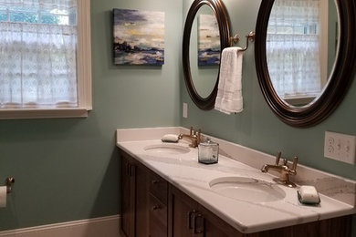 Example of a mid-sized transitional master porcelain tile and multicolored floor sliding shower door design in Raleigh with shaker cabinets, dark wood cabinets, a two-piece toilet, blue walls, an undermount sink and quartz countertops