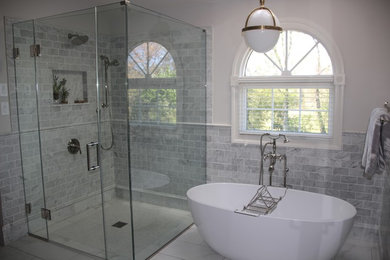 Example of a large transitional master subway tile porcelain tile and white floor bathroom design in Philadelphia with shaker cabinets, dark wood cabinets, gray walls, an undermount sink, marble countertops and a hinged shower door