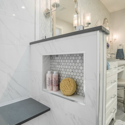 Example of a small transitional master white tile and marble tile porcelain tile and gray floor corner shower design in Dallas with shaker cabinets, white cabinets, a two-piece toilet, gray walls, an undermount sink, quartz countertops and a hinged shower door